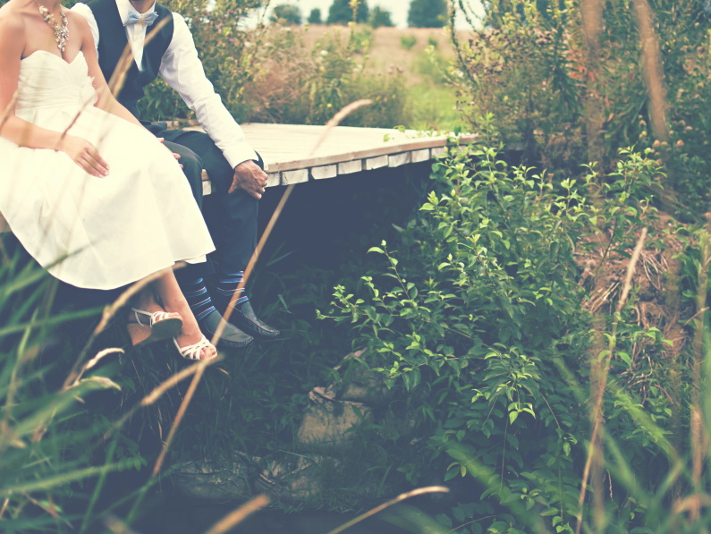 image of a couple just married, two young hearts, sitting on a dock